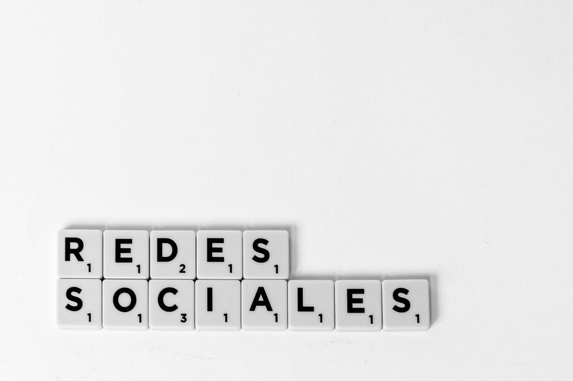 Scrabble tiles spelling 'Redes Sociales' illustrating a social media concept on a white background. — Like Pump Strategies fo