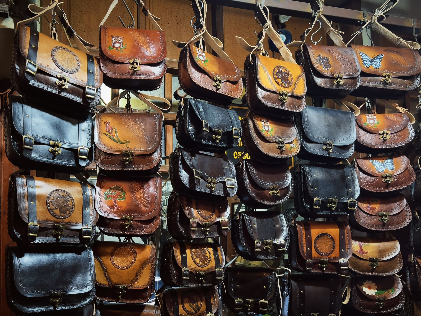 A collection of handcrafted leather bags with artistic designs on display at a shop. — NBA Streams: Watch the Finals Live Onl